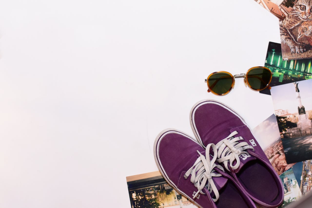 Purple sneakers and sunglasses with scattered photos on a white background.