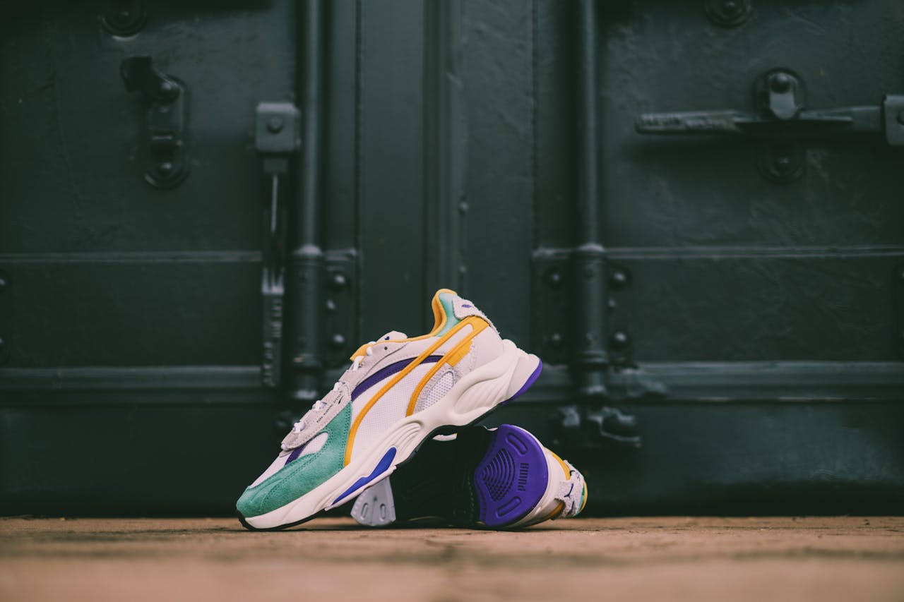 Colorful sneakers showcased against a dark industrial door, highlighting footwear design.